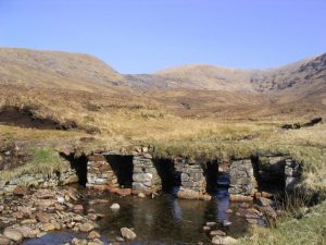 Bridge over tributaries of Abhainn an Loin. A somewhat overgrown but still an effective bridge over the burn. © Russel Wills, Geograph