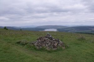 The cairn on Tamtain. Carron Reservoir and the hills and mountains of Argyll in the background. © Robert Murray, Geograph