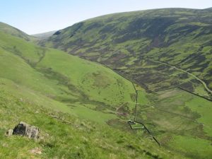 Looking down into the valley of the Kirk Burn, just north of Durisdeer, from a height of about 1000ft. In the centre of the picture can be seen the ditches and ramparts of the Durisdeer Roman fortlet with the line of the Roman Road running alongside. © Eileen Henderson, Geograph