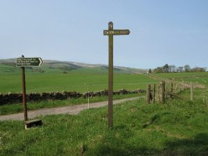NS873046: the start of the footpath north to the Enterkin Pass has two signposts (2007). The lefthand sign was erected by the Scottish Rights of Way Society, while the taller one on the right is marked 'CT'. The road in the photo leads to Inglestone Farm. © Eileen Henderson, Geograph