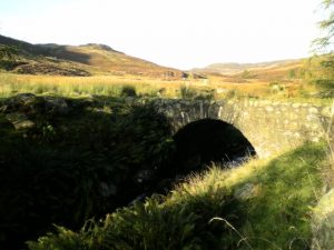 NN889318 Wade Bridge over the Lurg Burn (2007). Directly above the arch of the bridge the route of the old road can be seen flanked on either side by large stones. © John Hughes, Geograph