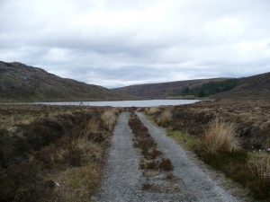 NH518837: the track crosses the watershed here at 410m after a long climb from Strath Rusdale and starts to descend (eventually) into Glen Calvie. Lochan a'Chairn can be seen in front. © Andrew Spenceley, Geograph