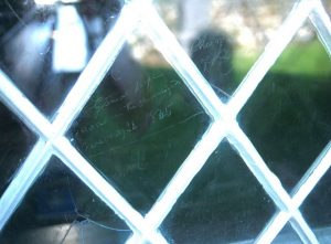 NH456914: names of people cleared from Glen Calvie in 1845 are scratched on the windows of Criock Church. They were sheltering from foul weather in the kirkyard, but would not enter the church out of respect. © Richard Webb, Geograph