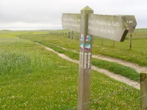 NF727296: dual language signposts on the Machair Way at Bornish (2011). The path follows the fertile west coast. © Colin Smith, Geograph