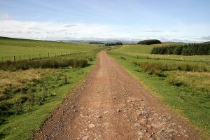 NT523584: a view south-west in the direction of Tollishill Farm with improved grazing fields either side. Heather is predominant where the road crosses over higher ground. © Walter Baxter, Geograph