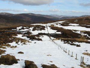 NO453696 looking NE at the stile which lies on the pass between Mount Sned and Hill of Mondurran, where this Mounth Road crosses the ridge (2009). It's a continution of the Clash of Wirren path and would have carried cattle, whisky and other traded goods. © Richard Webb, Geograph