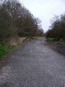 NS 702 777: this lay-by is the start of the route. It is the old line of the A803, now a quiet parking place for trucks. © BJ Smur, Geograph