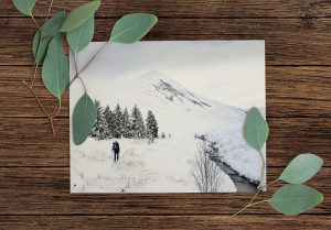 The Ben Wyvis Christmas card on a wooden table with leaves lying on the corners