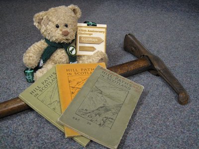 A teddy, medal, ice axe and three copies of Hill Paths in Scotland